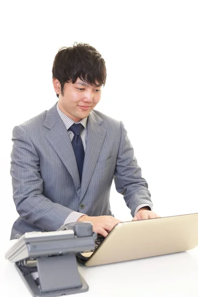 Hombre de negocios sonriente usando laptop —  Fotos de Stock