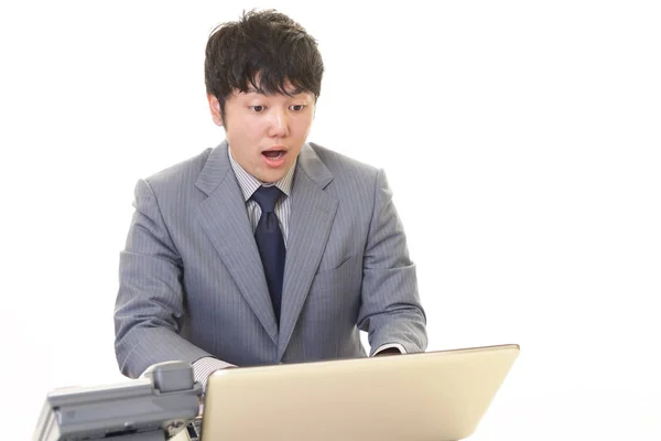 Здивований бізнесмен використовує ноутбук — стокове фото