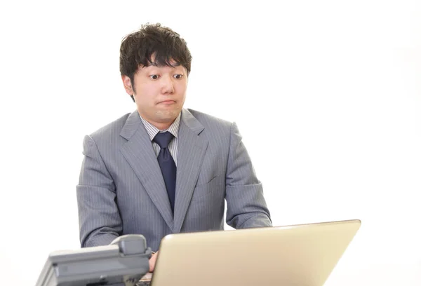 Surprised businessman using a laptop — Stock Photo, Image