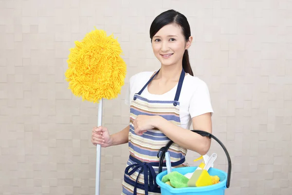 Sonriendo asiática ama de casa con un trapeador — Foto de Stock