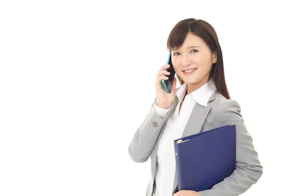 Mujer de negocios que está hablando por un teléfono inteligente — Foto de Stock
