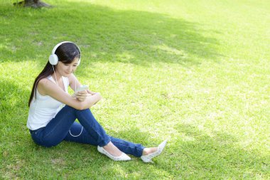 Genç bayan parkta dinleniyor.