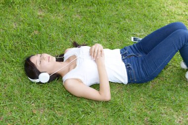 Genç bayan parkta dinleniyor.