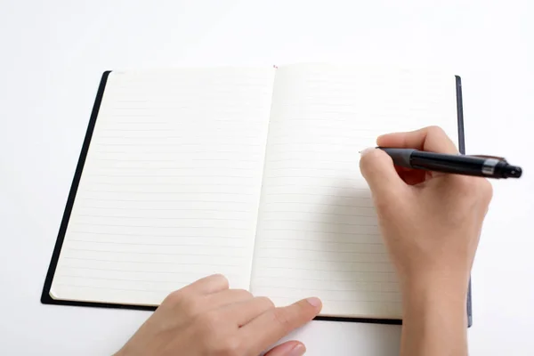 Vrouwelijke hand met pen schrijven op notebook Rechtenvrije Stockafbeeldingen