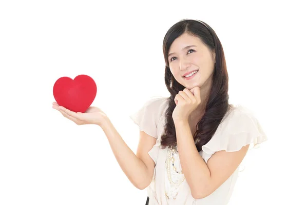 Mulher sorridente com um coração vermelho — Fotografia de Stock