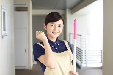 Bir süpürge ile Asya ev kadını gülümseyen