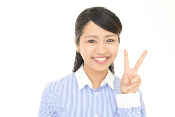 Lachende Aziatische vrouw geeft een V-teken — Stockfoto