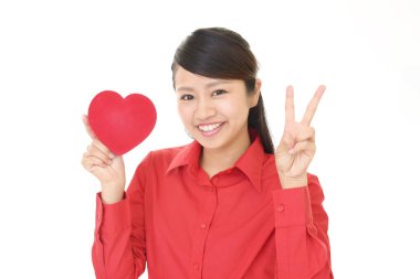 Kırmızı bir kalp ile gülümseyen kadın