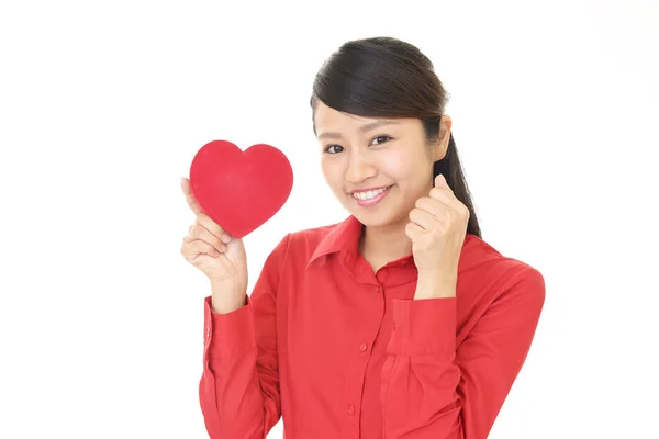 Mulher sorridente com um coração vermelho — Fotografia de Stock