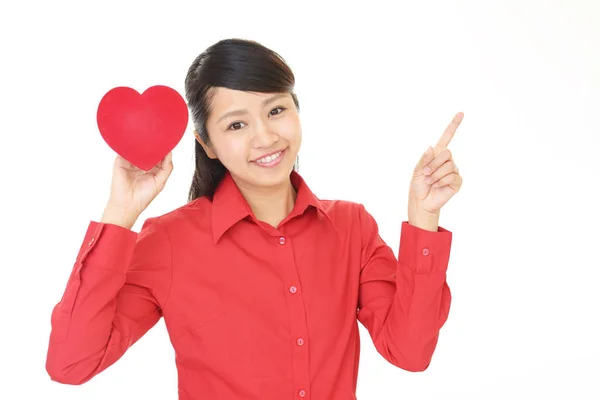 Mulher sorridente com um coração vermelho — Fotografia de Stock