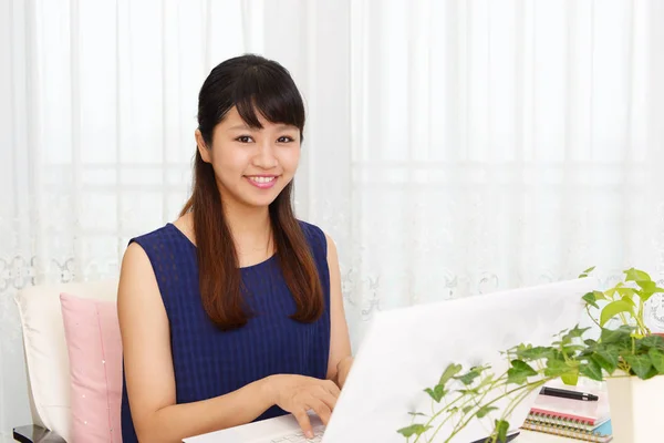 Smiling woman using a laptop — Stock Photo, Image