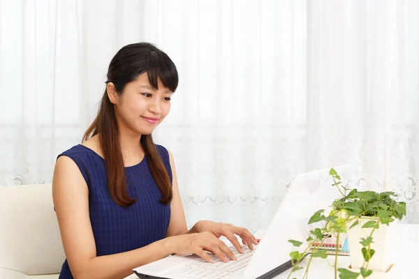 Mulher sorridente usando um laptop — Fotografia de Stock