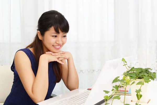 Mulher sorridente usando um laptop — Fotografia de Stock