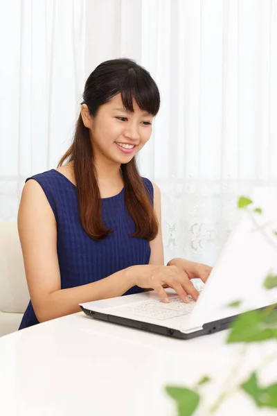 Mulher sorridente usando um laptop — Fotografia de Stock