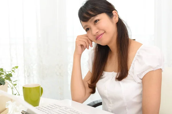 Mulher sorridente usando um laptop — Fotografia de Stock