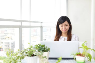 Gülümseyen kadın dizüstü bilgisayar kullanıyor.