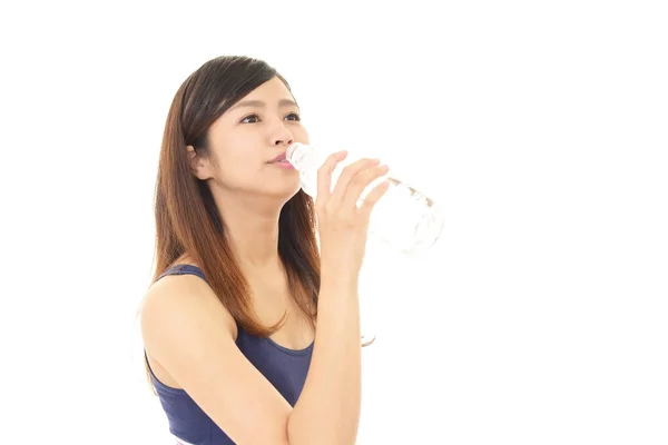 Woman drinking a bottle of water — Stock Photo, Image