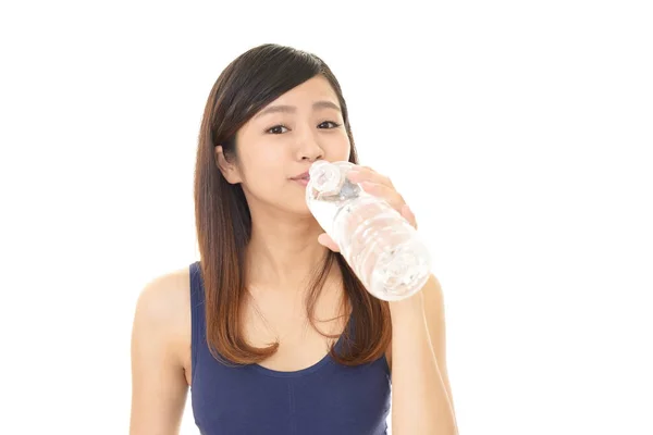 Woman drinking a bottle of water — Stock Photo, Image