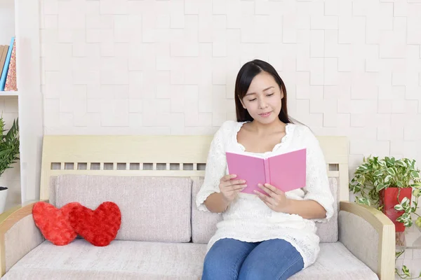 家で本を読んでいる女性は — ストック写真