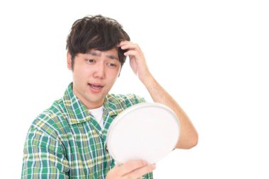 Adam saçlarıyla mutsuz görünüyor.