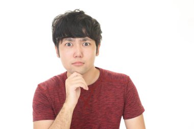 Şaşırmış Asyalı adam beyaz arka planda izole edilmiş.