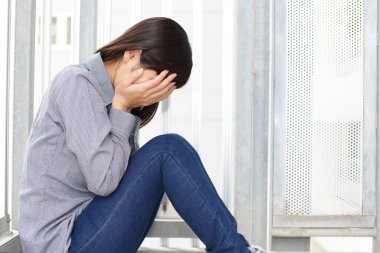 Üzgün genç bir kadın ağlıyor.