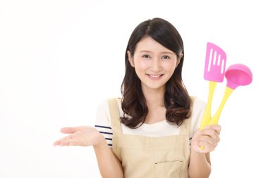 Mutfak eşyaları ile Asya ev kadını gülümseyen