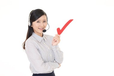 Çağrı Merkezi operatörü bir onay işareti ile gülümseyen