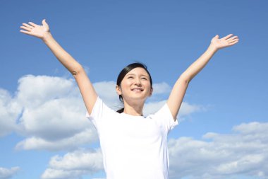 Rahat kadın mavi gökyüzü arka plan üzerinde izole