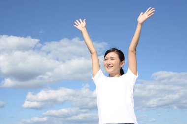 Rahat kadın mavi gökyüzü arka plan üzerinde izole