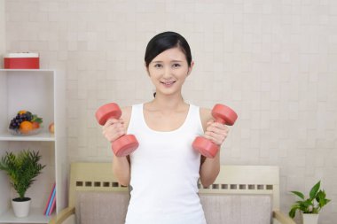 Dambıl ile egzersizleri bir genç kadın