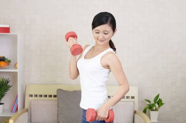 Dambıl ile egzersizleri bir genç kadın