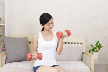 Dambıl ile egzersizleri bir genç kadın