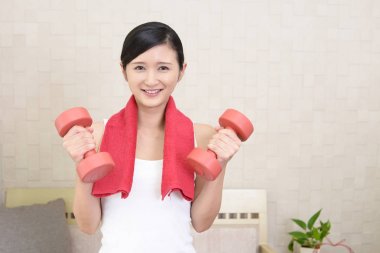 Dambıl ile egzersizleri bir genç kadın