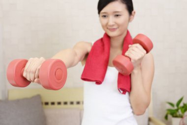 Dambıl ile egzersizleri bir genç kadın