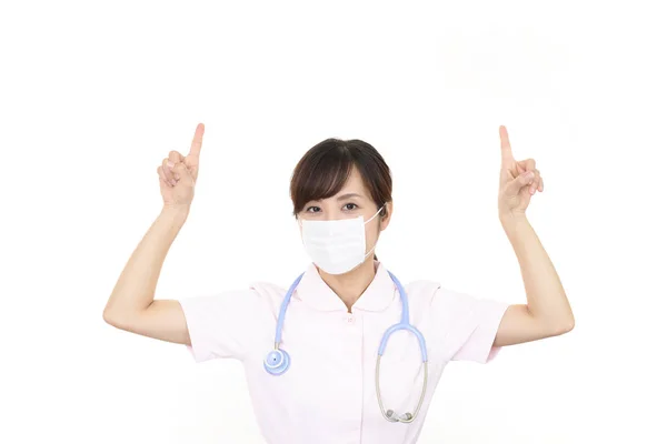 Kvinnlig Sjuksköterska Pekar Uppåt — Stockfoto