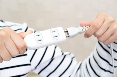 Elektrik Tak ve uzatma kablosu tutan kadın