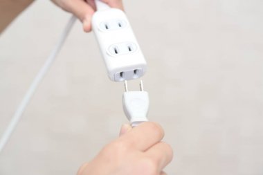Elektrik Tak ve uzatma kablosu tutan kadın