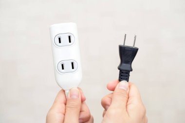 Elektrik Tak ve uzatma kablosu tutan kadın