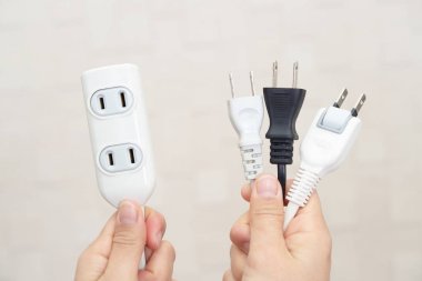 Elektrik Tak ve uzatma kablosu tutan kadın