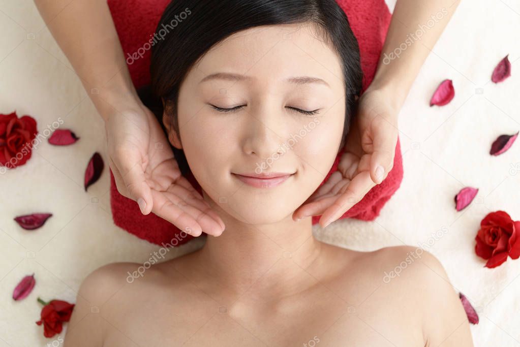 Beautiful young woman receiving facial massage