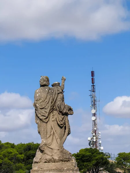 MAJORCA, SPAGNA - 7 SETTEMBRE 2007: Antica scultura situata sulla montagna vicino al monastero San Salvador punta alla moderna torre delle telecomunicazioni a Maiorca, Spagna, il 7 settembre 2007 — Foto Stock