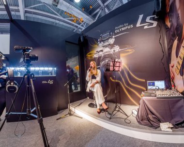 Moscow, Rusya Federasyonu - 21 Nisan 2017: Tanımlanamayan şarkıcı Art Space standında Olympus şirketi Photoforum 2017 ticaret fuarında Moskova, Rusya üzerinde 21 Nisan 2017 Ls-100 stereo pikap radyo sinyalleriyle iletilen yazmak gösterir