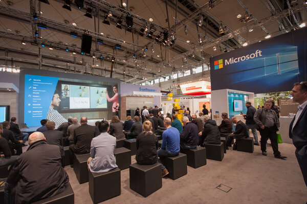 HANNOVER, GERMANY - MARCH 14, 2016: People listen presentation in booth of Microsoft company at CeBIT information technology trade show in Hannover, Germany on March 14, 2016