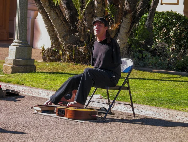 SAN DIEGO, CALIFORNIA - 12 DE MARZO DE 2007: Una persona sin brazos con discapacidad toca la guitarra con los dedos de los pies en Balboa Park, San Diego, California, el 12 de marzo de 2007 —  Fotos de Stock