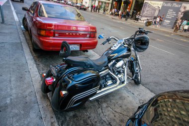 SAN FRANCISCO, ABD - SEPT 30, 2012: Siyah Harley Davidson Super Glide motosikleti gidonu üzerinde kask olan motor 30 Eylül 2012 'de San Francisco, ABD' de park alanında kalıyor.