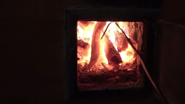 Man poking fire burning in old fireplace with rake — Stock Video