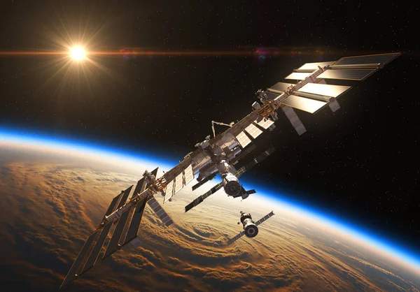 Международная космическая станция и космический корабль на фоне восходящего солнца — стоковое фото