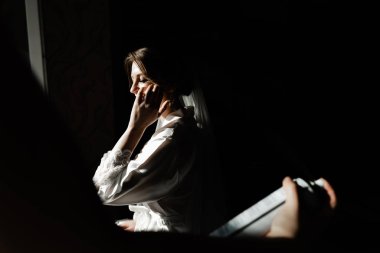 Genç ve güzel bir gelinin portresi. Düğün makyajı. Güzel kız damadı beklerken dairelerde düğün töreni için giyinir ve toplanır. Gelinin sabahı