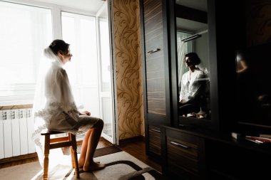 Genç ve güzel bir gelinin portresi. Düğün makyajı. Güzel kız damadı beklerken dairelerde düğün töreni için giyinir ve toplanır. Gelinin sabahı